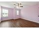 Inviting bedroom with ample light from the windows; features a ceiling fan and wood-look flooring at 4590 Wildener Way, Cumming, GA 30041