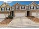 Exterior view of townhomes with two-car garages and driveways at 4590 Wildener Way, Cumming, GA 30041