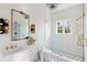White bathroom with elegant vanity, shower, tile floors, and decorative lighting at 3051 Habersham Nw Rd, Atlanta, GA 30305