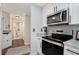Galley kitchen featuring stainless steel appliances, granite countertops, and white cabinetry at 3655 Habersham Ne Rd # 226-A, Atlanta, GA 30305