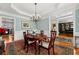 Formal dining room with an elegant chandelier, wainscoting, and access to other rooms at 730 Glenferry Trl, Atlanta, GA 30328