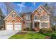 Charming two-story brick home with a well-manicured lawn and attached two-car garage at 730 Glenferry Trl, Atlanta, GA 30328
