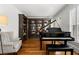 Elegant room with a grand piano, bookshelves, and a comfortable armchair at 730 Glenferry Trl, Atlanta, GA 30328