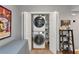 Modern laundry closet with stacked washer and dryer, art decor and a gray colored wall at 1115 Riverbend Club Drive Se Dr, Atlanta, GA 30339