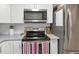 Efficient kitchen with stainless steel appliances, white cabinets, and modern countertops at 1115 Riverbend Club Se Dr, Atlanta, GA 30339