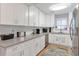 Modern kitchen with white cabinets, stainless steel appliances, and laminate flooring at 1115 Riverbend Club Se Dr, Atlanta, GA 30339