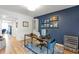 Inviting home office with wood floors, modern desk, display cabinet and blue accent wall with colorful artwork at 1115 Riverbend Club Se Dr, Atlanta, GA 30339