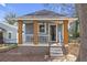 Charming bungalow with a cozy front porch, painted in inviting gray tones, and well-maintained front yard at 1146 Sims Sw St, Atlanta, GA 30310