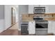 Well-lit kitchen featuring granite countertops, white cabinets and stainless-steel appliances at 1146 Sims Sw St, Atlanta, GA 30310