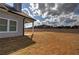 A spacious backyard with a covered patio and view of a brick building at 121 Sunflower Cir, Cartersville, GA 30121