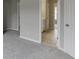 Hallway with neutral paint and carpet leading to tiled bathroom at 2856 Captain Ct, Dacula, GA 30019