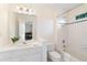 Well-lit bathroom with patterned wallpaper, white vanity, and shower-tub combo at 426 Lakestone Dr, Suwanee, GA 30024