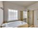 Bathroom with soaking tub, tile surround and separate glass-enclosed shower at 730 Pear Grove Pl, Marietta, GA 30066