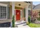 Close-up of a red front door with decorative accents, framed by green shrubbery and classic architectural details at 730 Pear Grove Pl, Marietta, GA 30066