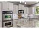 Well-equipped kitchen with stainless steel appliances, granite countertops, and white subway tile backsplash at 730 Pear Grove Pl, Marietta, GA 30066