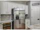 Modern kitchen featuring stainless steel refrigerator, wine cooler, granite countertops, and white cabinets at 730 Pear Grove Pl, Marietta, GA 30066