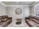 Cozy living room with plush seating, decorative wall clock, and natural light from the window at 730 Pear Grove Pl, Marietta, GA 30066