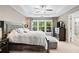 Comfortable main bedroom featuring a tray ceiling, large windows, and a decorative ceiling fan at 2471 Bridlewood Se Dr # 8, Atlanta, GA 30339