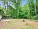 Expansive backyard with lush greenery and a peaceful, shaded area at 5626 Noblett Sw Rd, Stone Mountain, GA 30087