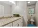 Bright bathroom features a granite countertop, a white vanity, and a separate toilet and shower area at 5626 Noblett Sw Rd, Stone Mountain, GA 30087