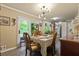 Bright dining room with modern lighting and a view to the outdoors through a large sliding glass door at 5626 Noblett Sw Rd, Stone Mountain, GA 30087