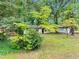 Lush front yard with mature trees, green grass, and partial view of the house at 5626 Noblett Sw Rd, Stone Mountain, GA 30087