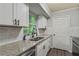 Modern kitchen featuring sleek countertops, stainless steel sink, subway tile backsplash, and ample storage space at 5626 Noblett Sw Rd, Stone Mountain, GA 30087