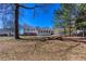 View of a large, grassy backyard with a house and mature trees at 1722 Johnston Nw Trl, Kennesaw, GA 30152