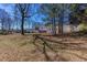 Backyard with a home in the distance, mature trees, and lush greenery at 1722 Johnston Nw Trl, Kennesaw, GA 30152