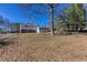 Large backyard with a home in the distance and mature trees at 1722 Johnston Nw Trl, Kennesaw, GA 30152