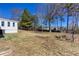 View of the backyard with a house addition, landscaping, and mature trees at 1722 Johnston Nw Trl, Kennesaw, GA 30152