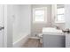 Bright bathroom featuring a gray vanity, white subway tile in the bath/shower, and a window offering natural light at 1722 Johnston Nw Trl, Kennesaw, GA 30152