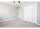 Spacious, neutrally-decorated bedroom featuring a ceiling fan, large closet, and soft gray carpet at 1722 Johnston Nw Trl, Kennesaw, GA 30152