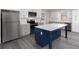 Bright kitchen with white cabinets, gray countertops, stainless steel appliances, and a large blue island at 1722 Johnston Nw Trl, Kennesaw, GA 30152
