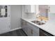 Bright gray countertops and cabinets with gold hardware and stainless steel sink at 1722 Johnston Nw Trl, Kennesaw, GA 30152