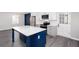 Eat-in kitchen featuring stainless appliances, white cabinets, gray counters, and a blue center island at 1722 Johnston Nw Trl, Kennesaw, GA 30152