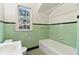 Bathroom with green tiles, black accent trim, and a white bathtub at 1815 Monroe Ne Dr, Atlanta, GA 30324