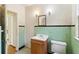 Bathroom featuring a green tiled wall, wooden vanity with a sink, and a toilet with a tiled floor at 1815 Monroe Ne Dr, Atlanta, GA 30324