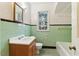 Bathroom featuring green tiles, a tiled floor, and wooden vanity with white sink at 1815 Monroe Ne Dr, Atlanta, GA 30324