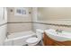 Bathroom features tiled walls, a shower-tub combo, toilet, and wooden vanity at 1815 Monroe Ne Dr, Atlanta, GA 30324