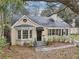 Charming home exterior with black door, gray roof, and lush greenery at 1815 Monroe Ne Dr, Atlanta, GA 30324