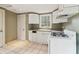 Kitchen with white cabinets, essential appliances, tiled floor, and window at 1815 Monroe Ne Dr, Atlanta, GA 30324