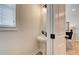 Stylish half bath featuring a pedestal sink, modern faucet, and decorative mirror, illuminated by sconce lighting at 1923 Cassia Aly, Kennesaw, GA 30144