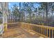 This spacious back deck features wood flooring and railing overlooking a natural area at 3175 Tackett Rd, Douglasville, GA 30135
