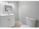 Clean bathroom featuring a toilet, sink, vanity with cabinet, and a mirror at 3175 Tackett Rd, Douglasville, GA 30135