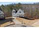 This exterior view shows a charming light-grey home with a garage and a curved driveway at 3175 Tackett Rd, Douglasville, GA 30135
