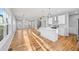 Open-concept kitchen and living area with hardwood floors, white cabinets, and island at 3175 Tackett Rd, Douglasville, GA 30135