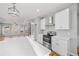 Bright kitchen featuring white cabinets, quartz countertops, and stainless steel appliances at 3175 Tackett Rd, Douglasville, GA 30135