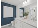 Modern bathroom features double sinks, white cabinets, large mirror, and stylish decor on a dark blue accent wall at 628 Topsail Drive Pkwy, Villa Rica, GA 30180