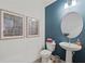 Bathroom featuring a pedestal sink, an oval mirror, and bold blue accent wall at 628 Topsail Drive Pkwy, Villa Rica, GA 30180